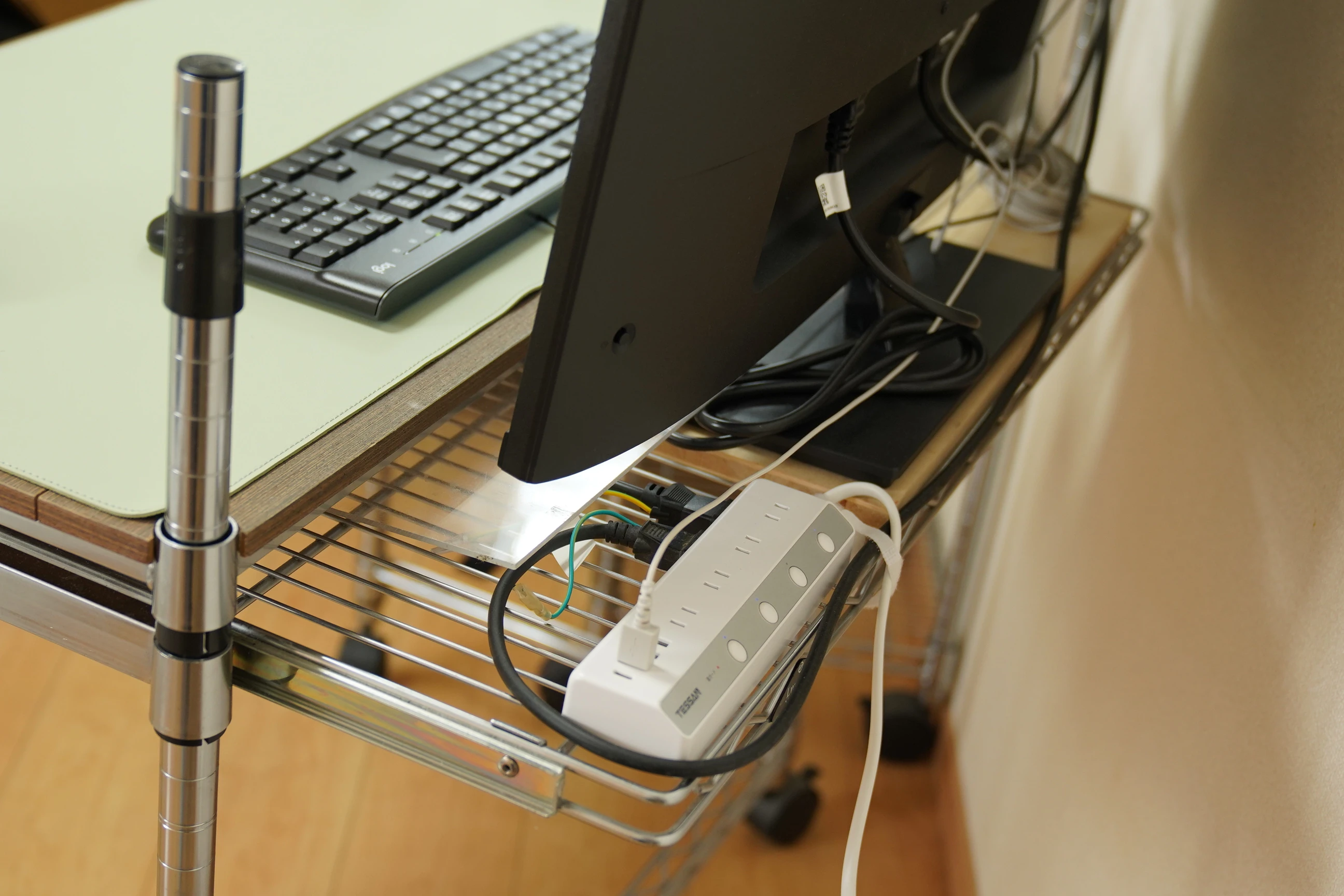 The monitor from behind, with its stand on the shelf area behind the working desktop